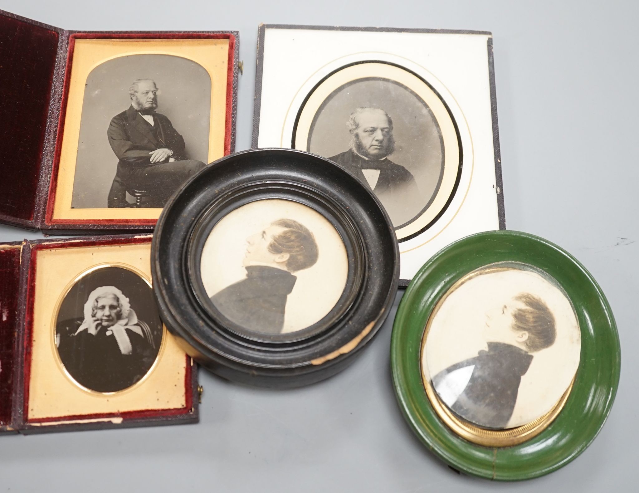 A collection of Victorian photographs etc including a tinted daguerreotype, three portrait miniatures and cabinet cards